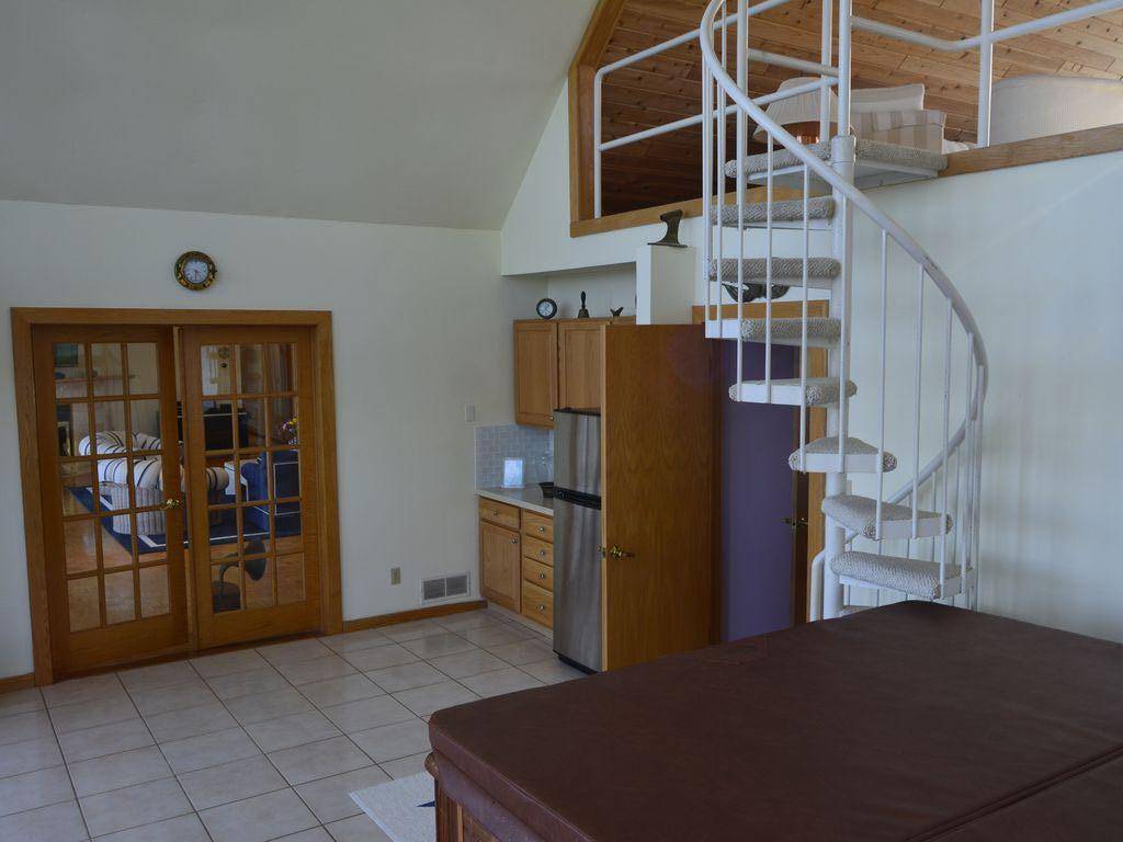 Solarium with stairs leading to loft sitting area, open door